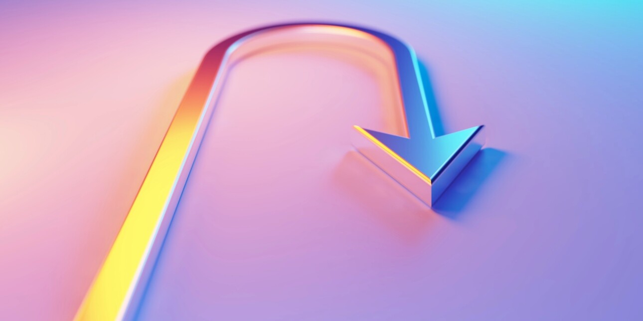 A metallic u-turn symbol with an arrow head, which is illuminated by blue and magenta lights on a blue and magenta background